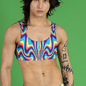 May include: A person wearing a rainbow-colored swimsuit with a psychedelic pattern. The swimsuit has a scoop neck and a low-cut back. The person is wearing black platform boots.