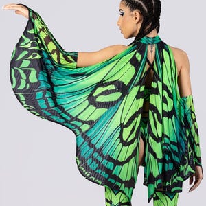 May include: A vibrant green and black butterfly wing-inspired outfit. The ensemble includes a halter top, flared pants, and matching arm sleeves. The design features a detailed butterfly wing pattern with shades of green and black.