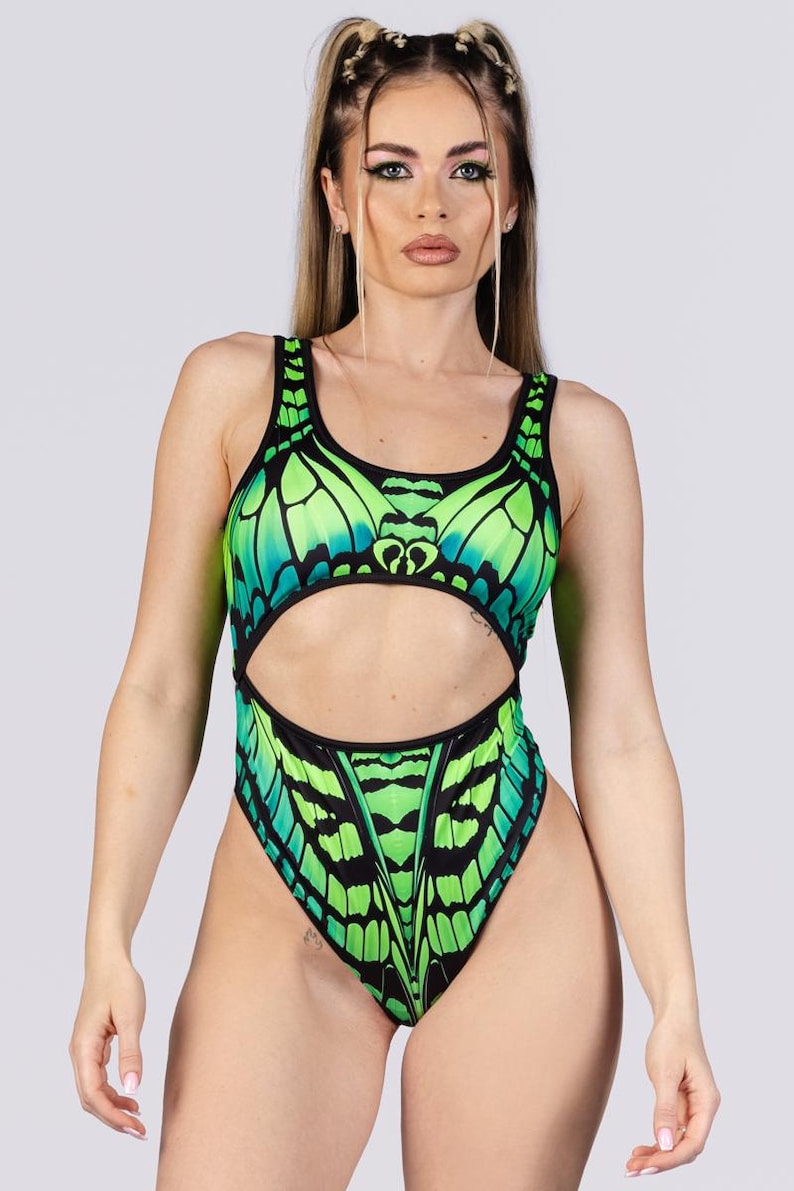 May include: A one-piece swimsuit with a butterfly wing design in shades of green and black. The swimsuit has a cutout at the waist and a high-cut leg. The butterfly wing pattern is detailed and vibrant.