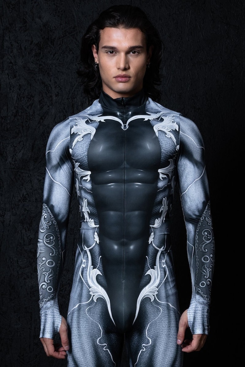 May include: A black and white bodysuit with a detailed, ornate design. The bodysuit has a zip at the front and long sleeves.