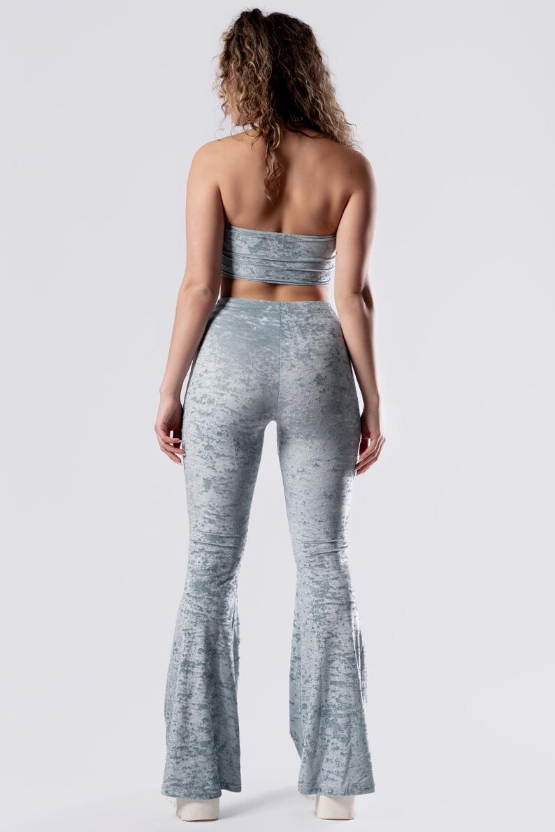 Op de afbeelding: Een lichtblauwe twee-delige outfit met een tube top en een broek met wijde pijpen. De stof heeft een subtiele distressed look.
