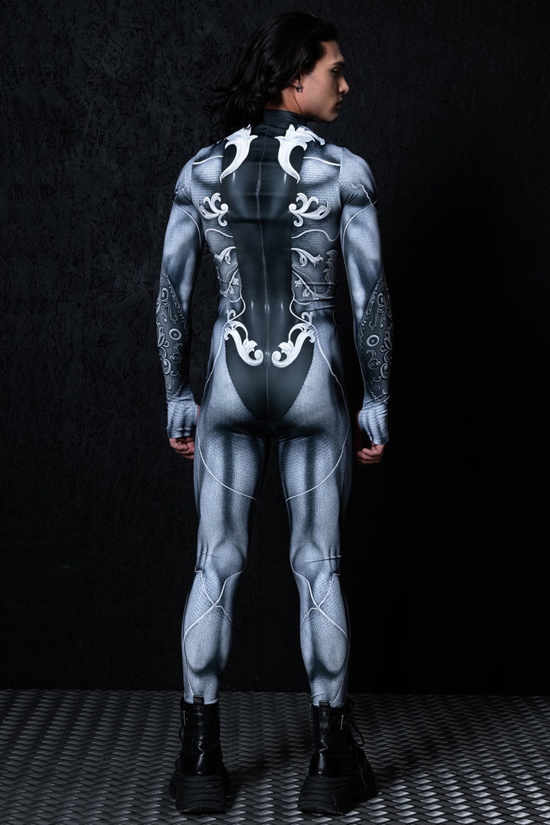 May include: A full-body suit with a silver and black design featuring intricate patterns. The suit is form-fitting and has a high neck.