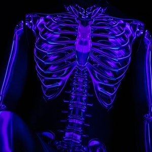 May include: A person wearing a black bodysuit with a glow-in-the-dark skeleton design. The skeleton is outlined in purple and blue.