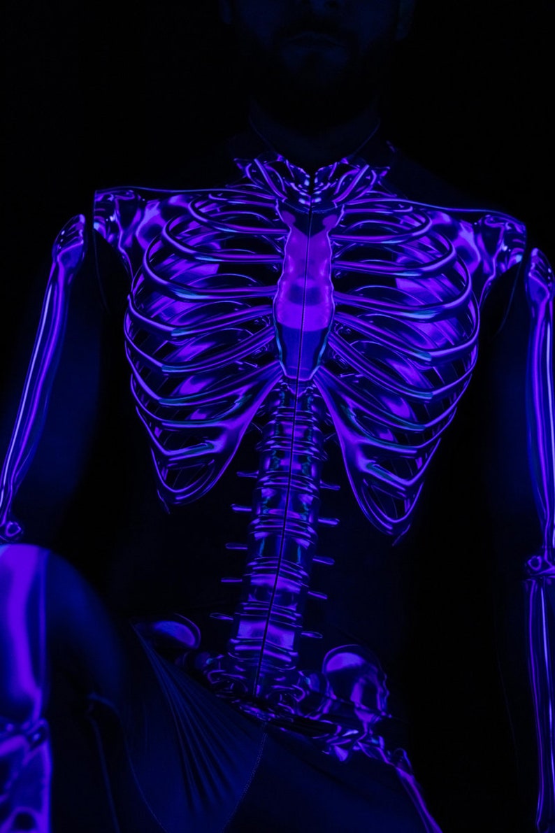 May include: A person wearing a black bodysuit with a glow-in-the-dark skeleton design. The skeleton is outlined in purple and blue.