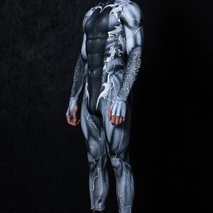 May include: A person wearing a black and white bodysuit with a detailed, intricate design. The bodysuit has a high neck and long sleeves. The person is wearing black boots.