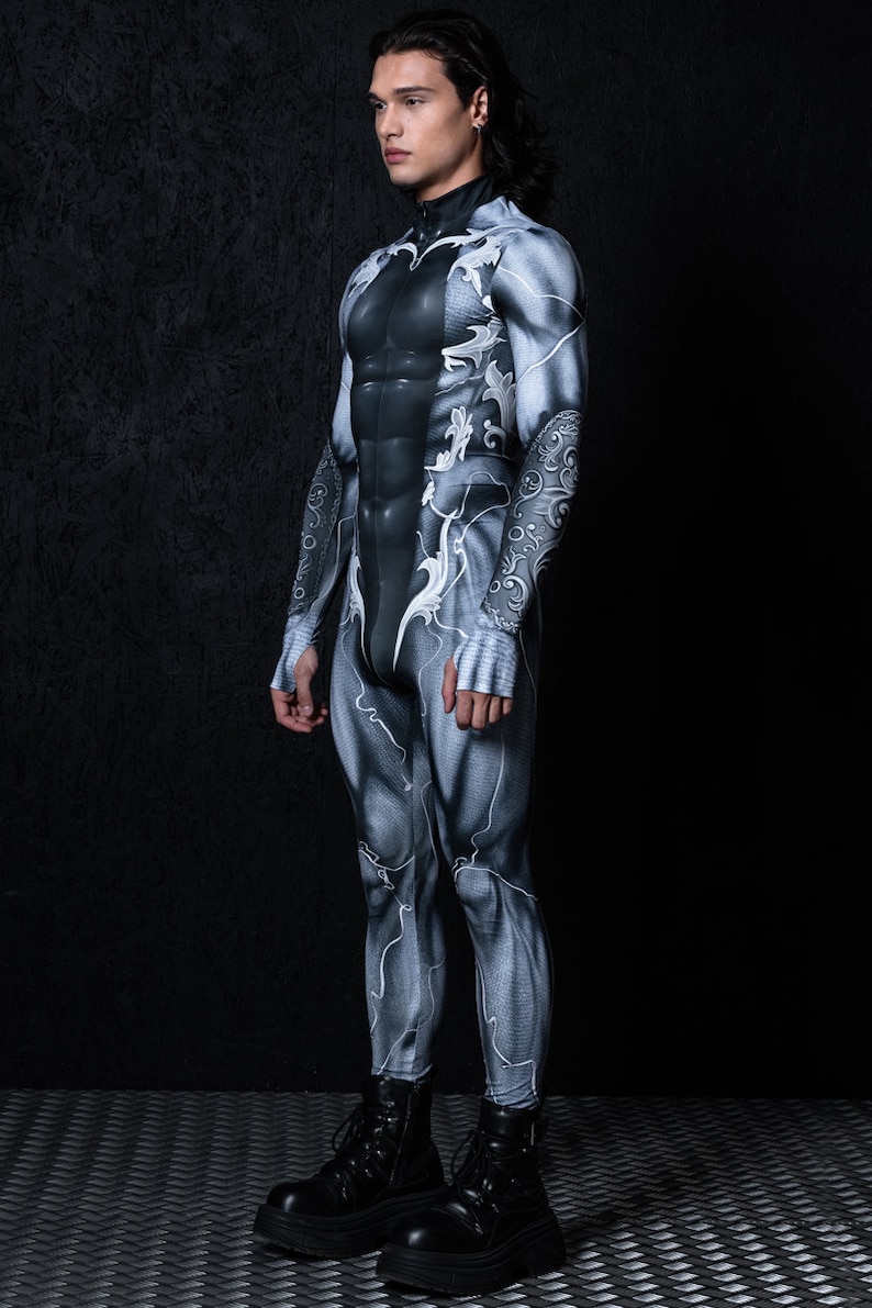 May include: A person wearing a black and white bodysuit with a detailed, intricate design. The bodysuit has a high neck and long sleeves. The person is wearing black boots.