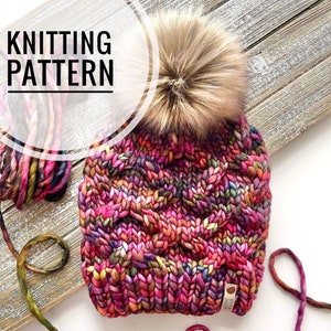 May include: Knitting pattern for a colorful beanie with a fluffy pom pom. The beanie is made with a chunky yarn and has a cable knit pattern. The yarn is labeled "Weird Sheep".