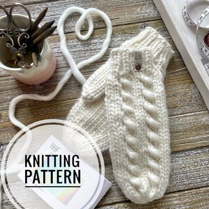 May include: White knitted mittens with a cable stitch pattern. The mittens have a leather tag that says "Weird Sheep".