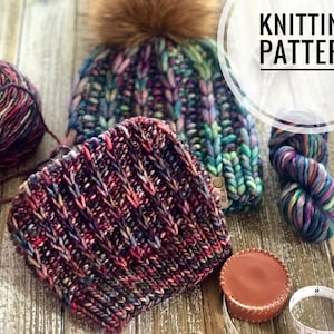 May include: A knitting pattern for a colourful beanie hat with a pom pom. The hat is made with a chunky yarn in shades of purple, blue, green, and red. The pattern includes a close-up of the knit stitch and a ball of yarn.