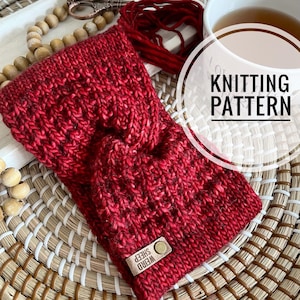 May include: A red knitted headband with a brown leather tag that says "Weird Sheep". The headband is on a woven wicker surface. The text "Knitting Pattern" is in a white circle on a white background.