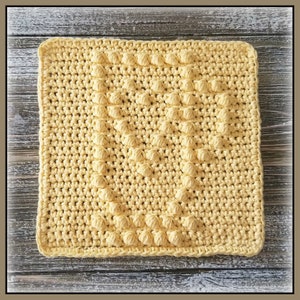 Könnte beinhalten: Ein quadratischer gelber Topflappen aus Häkelarbeit mit einem strukturierten Muster.