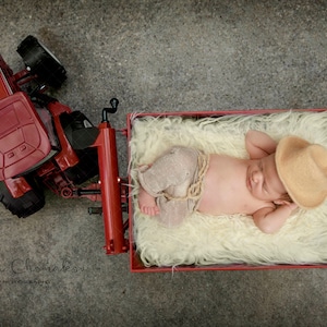 digitale Hintergrund Hintergrund Neugeborenes Baby Mädchen oder junge Traktor über Kopf rot aussehen