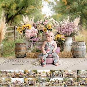 May include: A baby girl sits on a pink stool in front of a rustic backdrop. The backdrop features hay bales, wooden barrels, and floral arrangements in shades of pink, yellow, and green. The baby is wearing a floral print dress and has a flower in her hair.