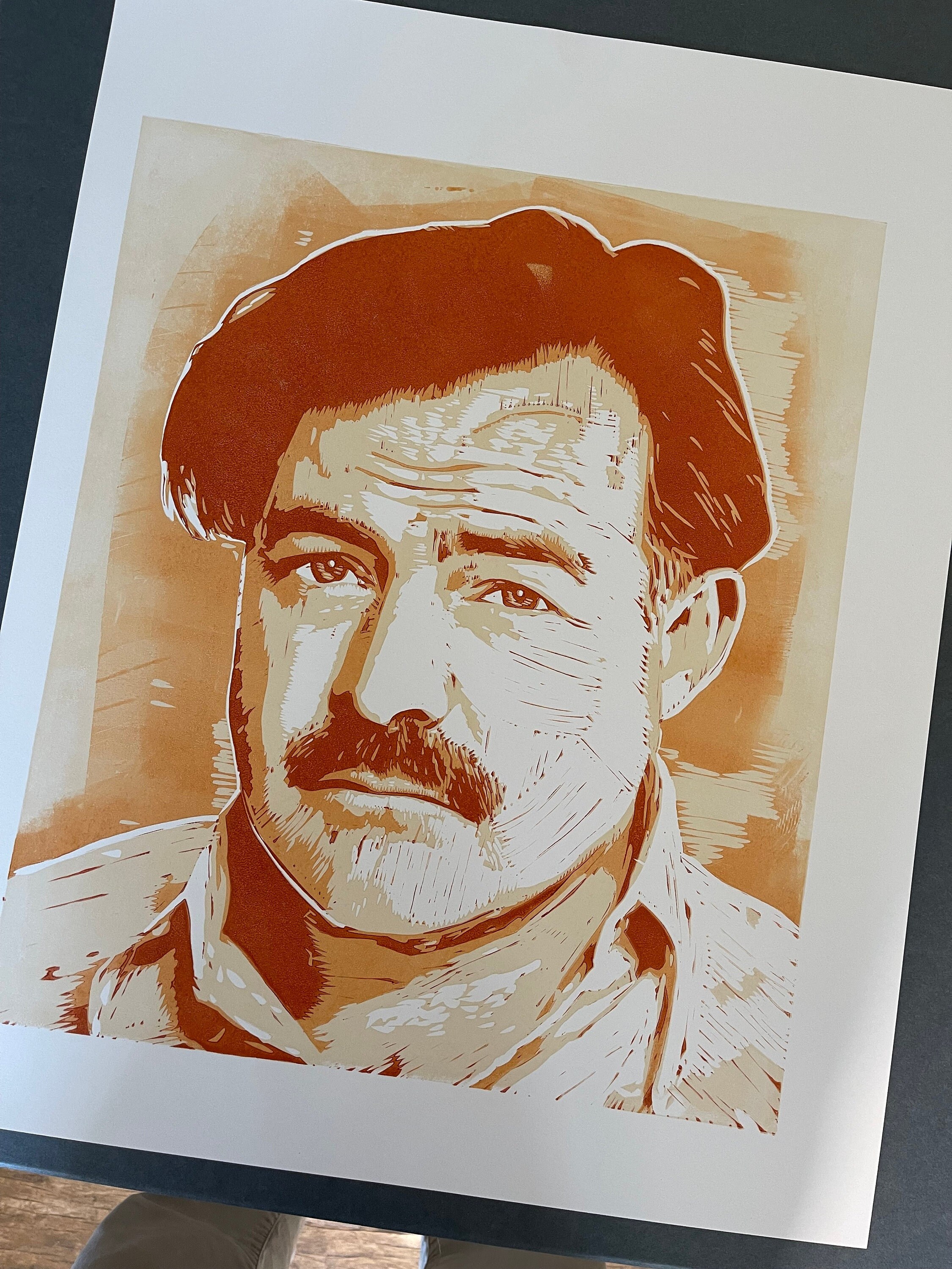 Portrait d’Ernest Hemingway, en linogravure, papier 24 » x 18 », par Tom Callos. Édition limitée de 8 tirages.