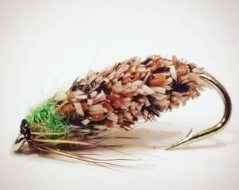May include: A brown, green, and white fly fishing lure with a gold hook.