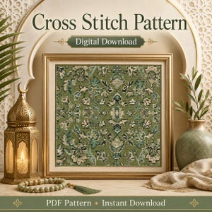 May include: A digital cross stitch pattern featuring an intricate, symmetrical floral design in shades of sage green, olive, and cream. The framed artwork is displayed with a gold lantern, a green vase, and prayer beads on a flat surface.