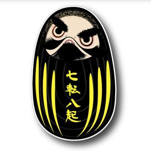 May include: Black and yellow daruma doll with a fierce expression and the Japanese characters "七転八起" written on the front. The characters mean "fall seven times, stand up eight".