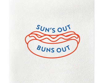 May include: White square napkin with the text "SUN'S OUT BUNS OUT" in blue and a red hot dog illustration. The hot dog has a red wavy line of ketchup. The napkin has a textured appearance.