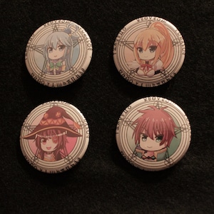 May include: Four round buttons with anime characters from the show Konosuba. Each button features a different character with a circular design around them. The characters are Aqua, Megumin, Darkness, and Kazuma.