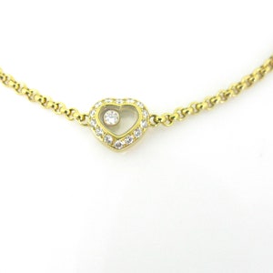 May include: A gold chain bracelet with a heart-shaped pendant. The pendant is set with diamonds and has a small diamond floating inside.