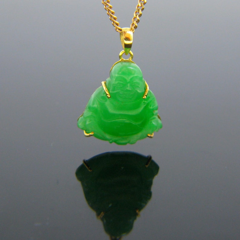May include: A green jade pendant of a smiling Buddha, set in gold, on a gold chain.