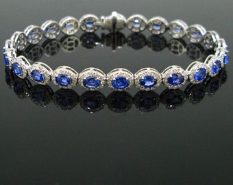 May include: A silver bracelet with oval-shaped blue sapphires set in a halo of diamonds.