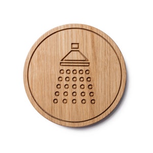 May include: A round wooden sign with a shower head icon engraved in the center. The icon is a simple line drawing of a shower head with water droplets.