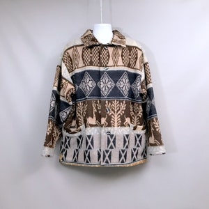 Könnte beinhalten: Eine braune, beige und graue gemusterte Jacke mit Knopfleiste. Die Jacke hat ein geometrisches Muster mit Hirsch-Silhouetten.