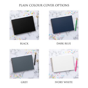 May include: Four different color options for a spiral bound notebook. The colors are black, dark blue, grey, and ivory white. Each notebook is shown on a white marble surface with confetti.