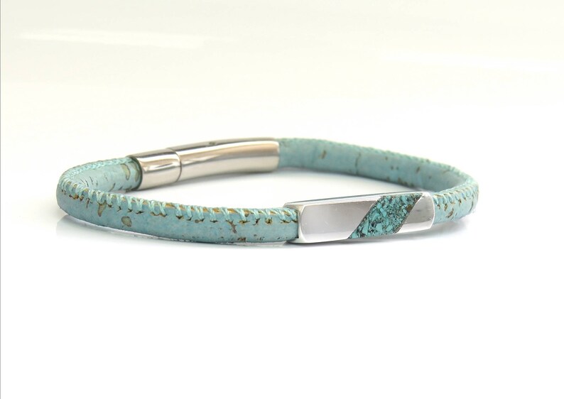 Peut inclure: Un bracelet en cuir bleu clair avec un fermoir argent&eacute; et une incrustation turquoise. Le bracelet est en li&egrave;ge et a un bord cousu.