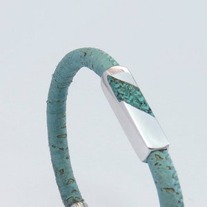 Peut inclure: Un bracelet en cuir turquoise avec un fermoir argent&eacute; incrust&eacute; de pierres turquoise.