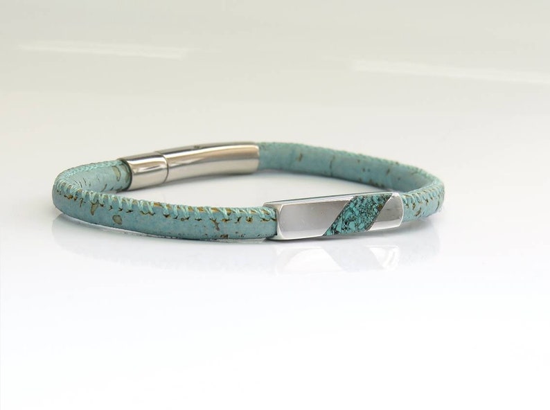 Peut inclure: Un bracelet en li&egrave;ge bleu clair avec un fermoir argent&eacute; et une barre argent&eacute;e avec une incrustation turquoise.