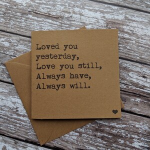 Puede incluir: Una tarjeta marr&oacute;n con el texto "Loved you yesterday, Love you still, Always have, Always will." impreso en negro. Un peque&ntilde;o coraz&oacute;n negro est&aacute; impreso en la esquina inferior derecha.