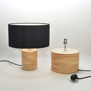 Puede incluir: Dos l&aacute;mparas de mesa de madera con pantallas de tela negra. Las l&aacute;mparas tienen un acabado de madera natural y ambas est&aacute;n enchufadas.