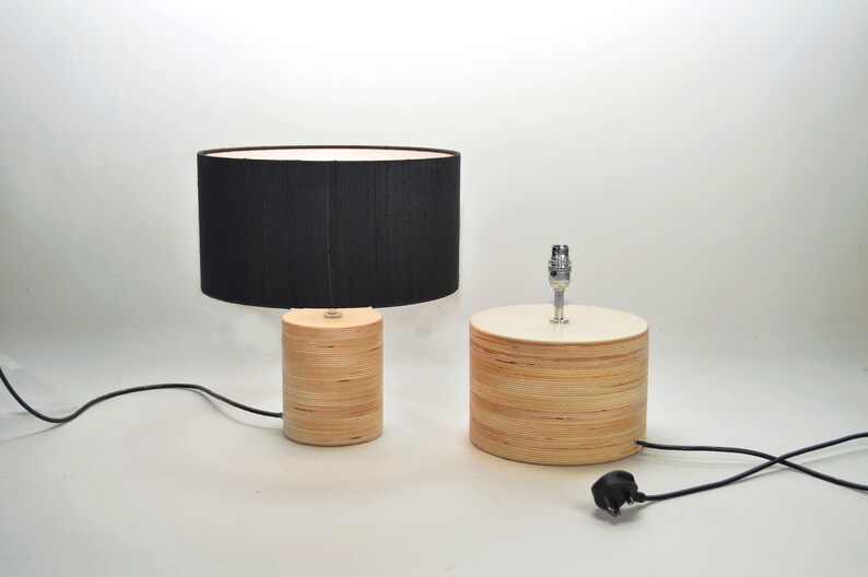 Puede incluir: Dos l&aacute;mparas de mesa de madera con pantallas de tela negra. Las l&aacute;mparas tienen un acabado de madera natural y ambas est&aacute;n enchufadas.