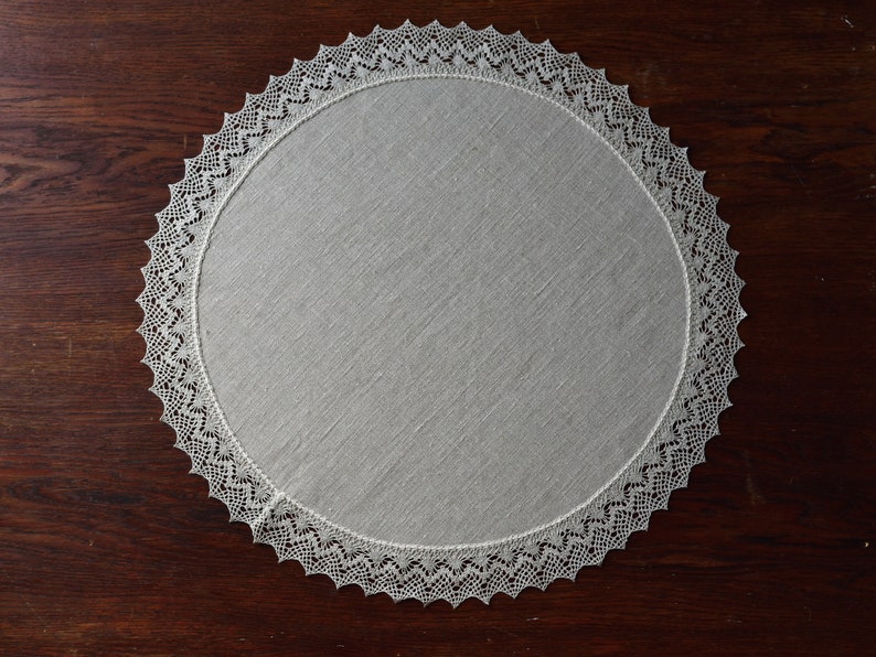May include: A white round crocheted doily with a delicate lace pattern.