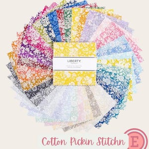 Pode incluir: Uma pilha de quadrados de tecido dispostos num padrão de leque circular. Cada peça apresenta uma estampa floral em várias cores, incluindo amarelo, azul, rosa, verde e roxo. Uma faixa de papel branca com o rótulo LIBERTY FABRICS envolve o centro.