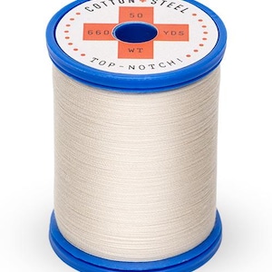 Könnte beinhalten: Eine Spule weißen Baumwollfadens mit einer blauen Kunststoffspule. Das Etikett lautet "Cotton + Steel", "50 WT", "660 YDS" und "Top-Notch!"