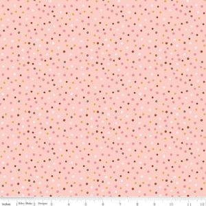 May include: Pink fabric featuring a polka dot design. The dots are in white, brown, gold, and pink hues. The fabric is marked with inches along the bottom edge.