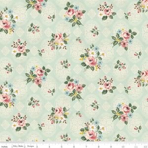 Pode incluir: Tecido floral com um padrão repetido de rosas cor-de-rosa, flores azuis e amarelas e folhas verdes. As flores são dispostas em bouquets sobre um fundo verde-água claro com um desenho de damasco creme.