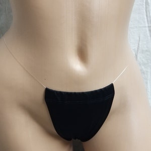 May include: Black lingerie with a thin clear strap. The lingerie is made of a soft, stretchy fabric.