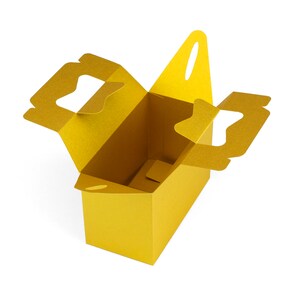 May include: A gold cardboard box with two cut-out handles on the sides and one on the top. The box is open and empty.