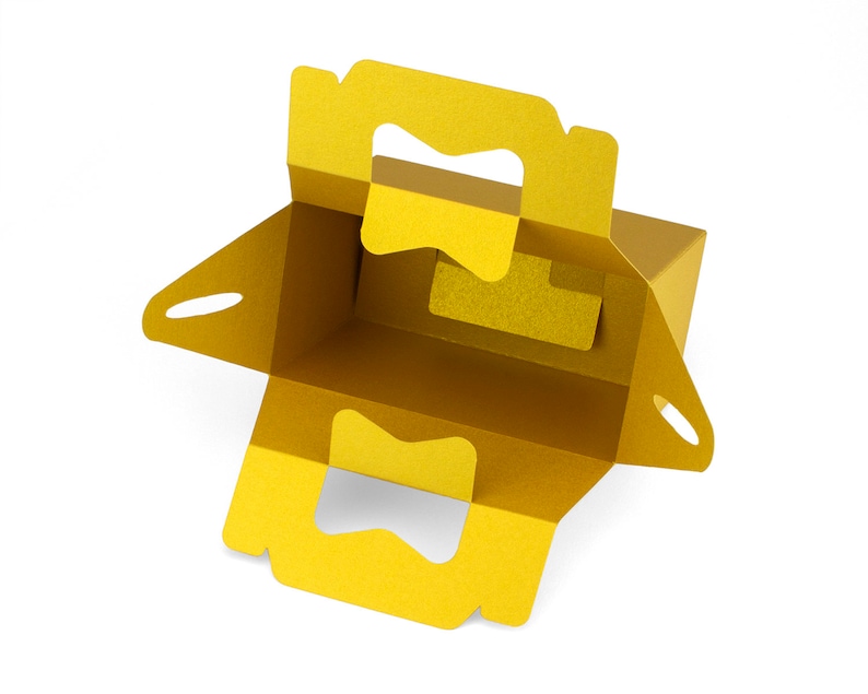 May include: A yellow cardboard box with cut-out handles and a fold-over top. The box is open and empty.