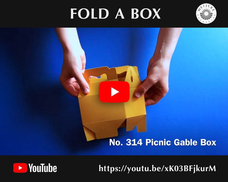 May include: A yellow cardboard box with a handle is being folded into a gable box shape. The box is labeled "No. 314 Picnic Gable Box". A YouTube play button is visible in the image. The text "https://youtu.be/xK03BFjkurM" is also visible.