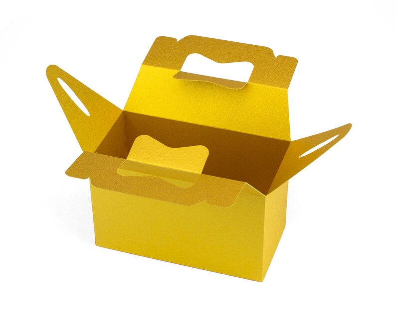 May include: A gold cardboard box with a handle, open and ready to be filled. The box is made of sturdy cardboard and has a smooth finish.