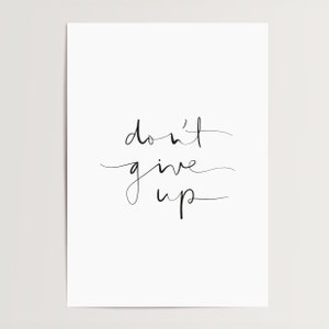 Puede incluir: Una impresi&oacute;n blanca minimalista con la frase motivacional "don't give up" en escritura cursiva negra. El dise&ntilde;o sencillo es adecuado para varios estilos de interior. El texto est&aacute; centrado.