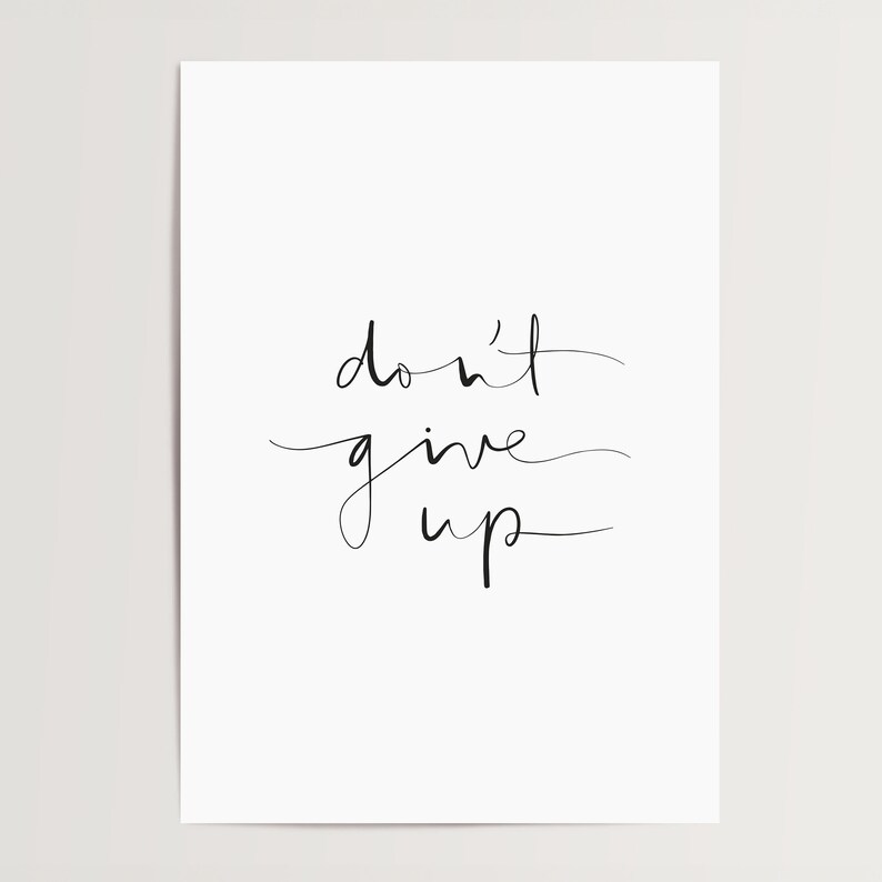 Puede incluir: Una impresi&oacute;n blanca minimalista con la frase motivacional "don't give up" en escritura cursiva negra. El dise&ntilde;o sencillo es adecuado para varios estilos de interior. El texto est&aacute; centrado.