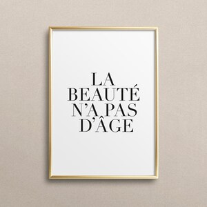 Puede incluir: Una impresi&oacute;n enmarcada en dorado con el texto "LA BEAUT&Eacute; N'A PAS D'&Acirc;GE" en negro.