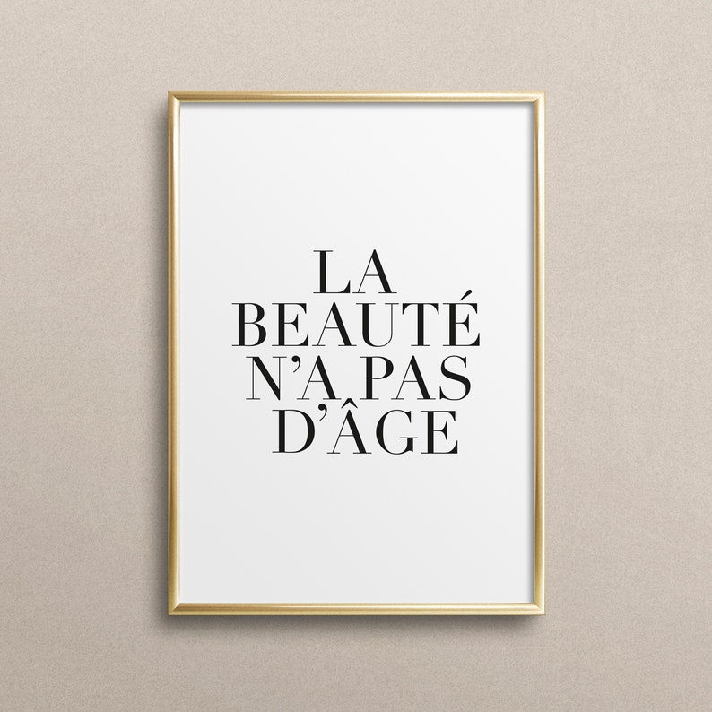 Puede incluir: Una impresi&oacute;n enmarcada en dorado con el texto "LA BEAUT&Eacute; N'A PAS D'&Acirc;GE" en negro.