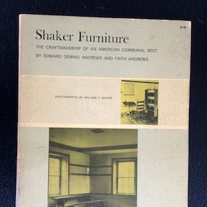 May include: A vintage book cover titled "Shaker Furniture" with text about American craftsmanship. The cover features a sepia-toned photograph of a room with windows and benches. The book's price is $2.00.